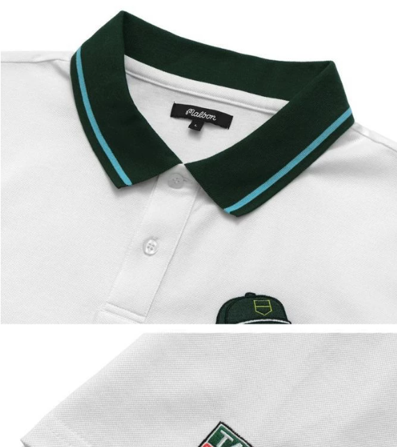 Malbon men's white golf polo with green collar tipping and embroidered chest logo on a white background