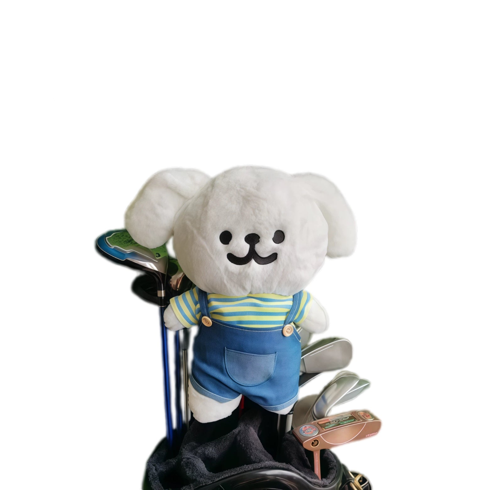 White puppy plush golf headcover wearing a striped yellow-and-blue tee and denim overalls, on a club in a bag