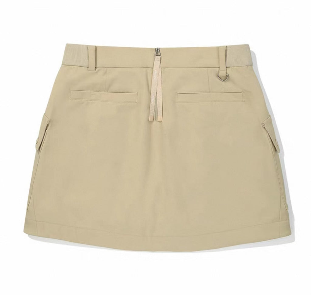 Malbon women's solid pleated golf skort with pockets in Khaki, back view