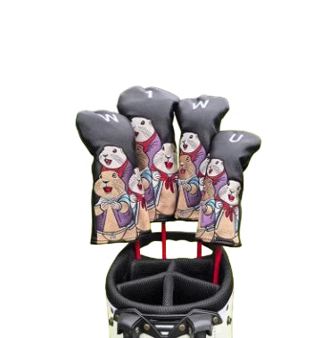 Front view of a black marmot golf headcover set with vibrant cartoon marmot illustrations, red scarves, and clear club labels ("W", "U", "1"), neatly arranged in a golf bag for protection and style.