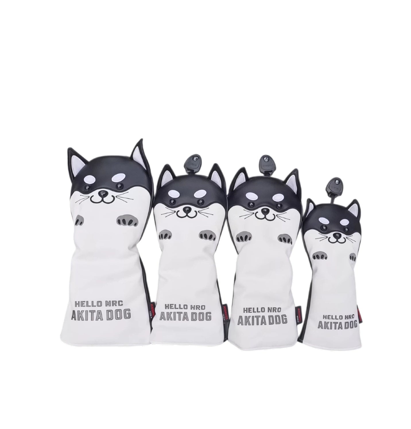 Front view of a four-piece black and white Akita Inu golf headcover set featuring cartoon-style dog faces with expressive eyes and paws, labeled "HELLO NRC AKITA DOG" — ideal for driver, fairway, hybrid, and utility clubs.