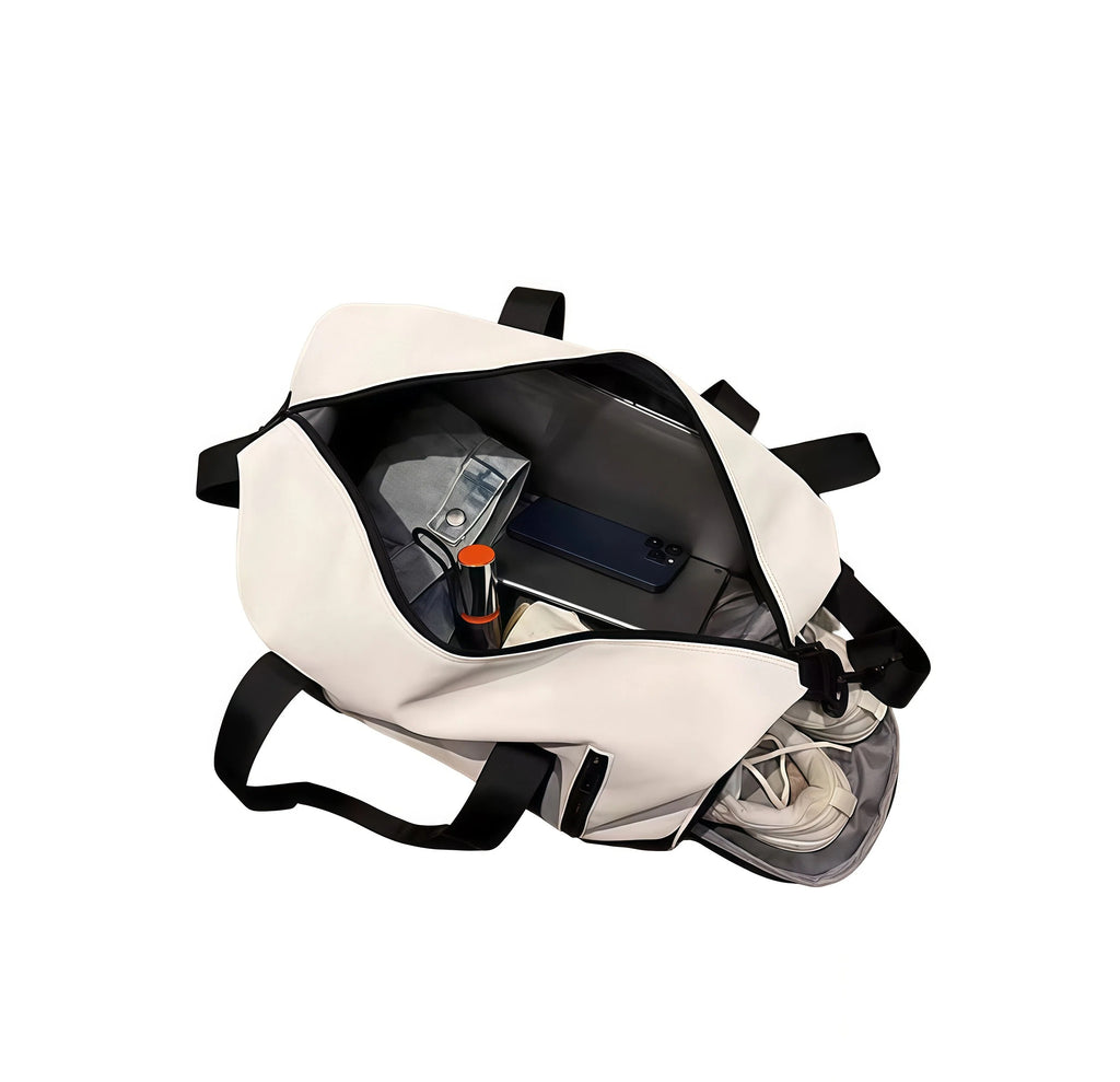 Open interior view of the Callaway Sport Hanba 1984 duffel bag showing clothes, phone, laptop, and shoes. Features spacious main compartment and dedicated shoe storage for hygiene.