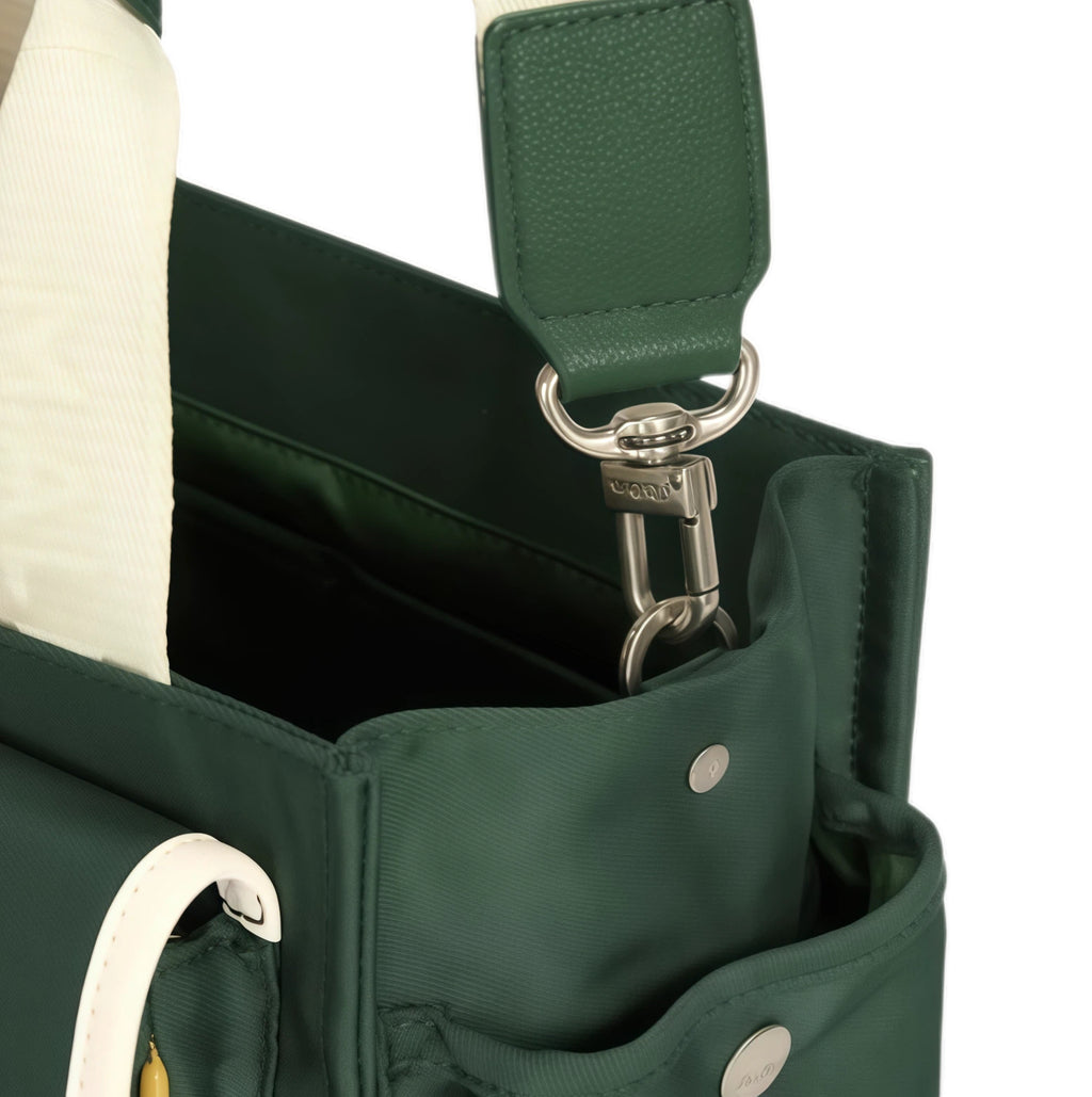 Close-up of Malbon golf bag hardware showing durable metal clasp, stitched leather-like reinforcement, and secure attachment point for shoulder strap.