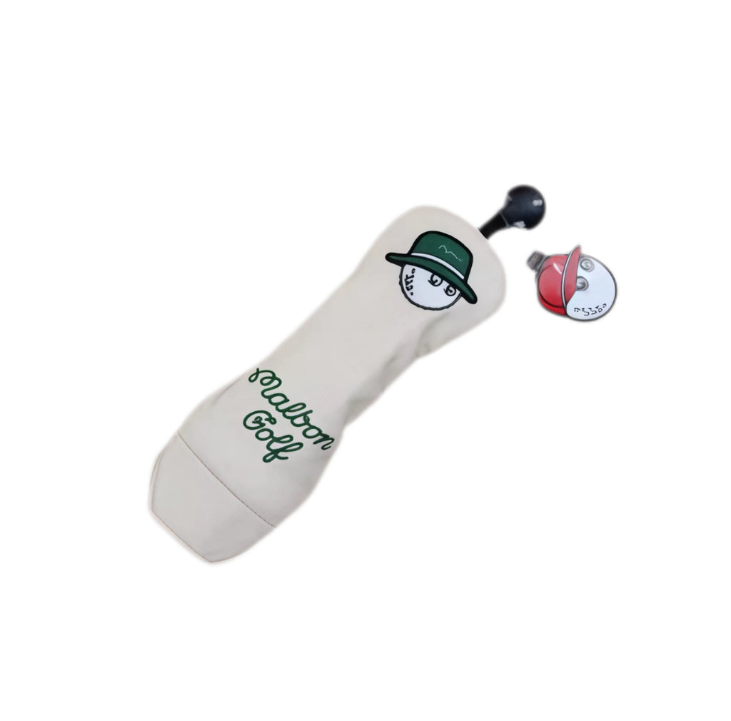 Angled shot of cream Malbon driver headcover displaying single large bucket hat character on front, “Malbon Golf” script embroidery at base, and detachable magnetic ball clip with red cap design.