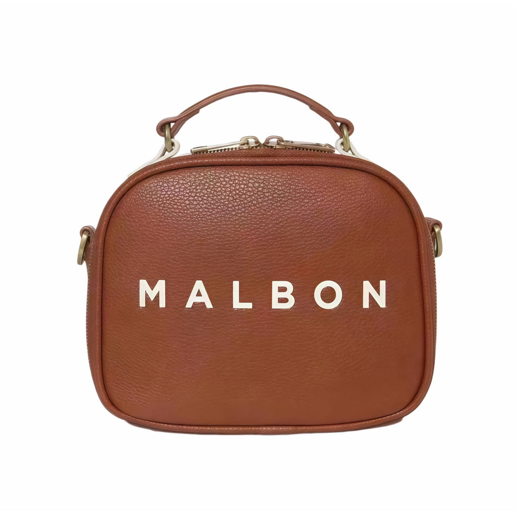 Front view of Malbon Golf Heritage Boston bag in tan brown featuring large white "MALBON" lettering across center, top handle, and clean structured silhouette
