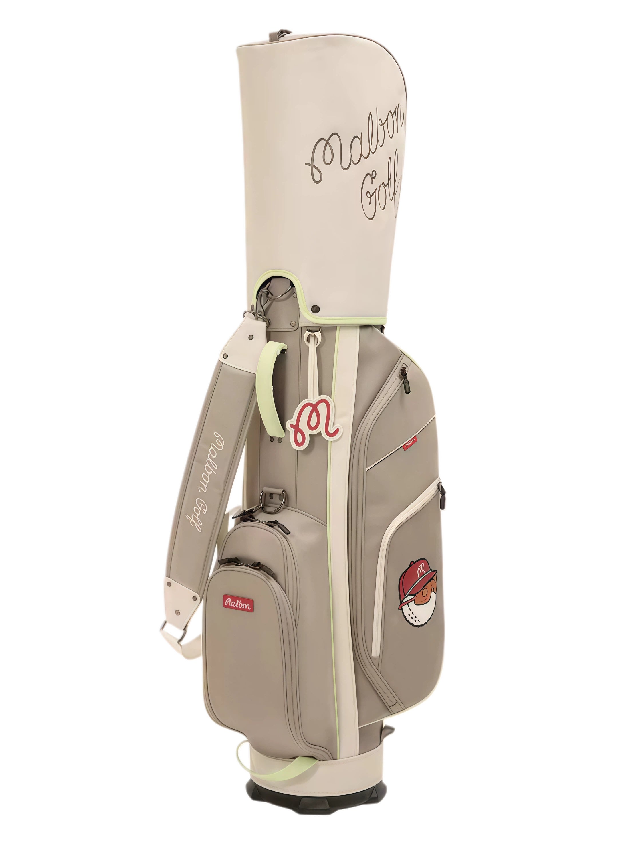 Side angle of beige Malbon Golf Heritage stand bag with shoulder strap, red “M” charm, and branded golf ball mascot on the lower panel