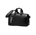 High-angle shot of the black Titleist Tech Duffel highlighting the carbon fiber-inspired side panel, white "Titleist" logo, and premium synthetic material. Perfect for golf and gym use.